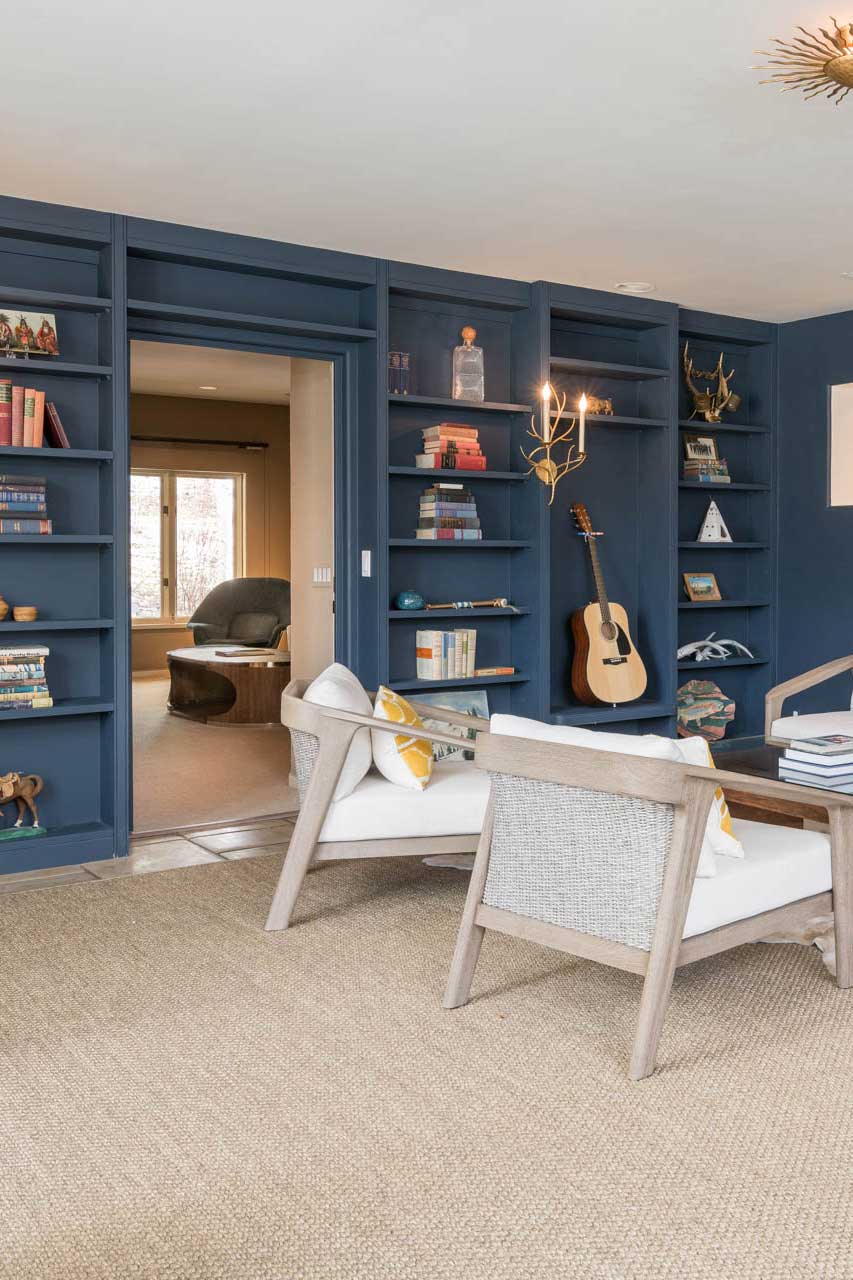 deep blue bookshelf for travel reading and music playing on vacation while lounging in living room at your rental home