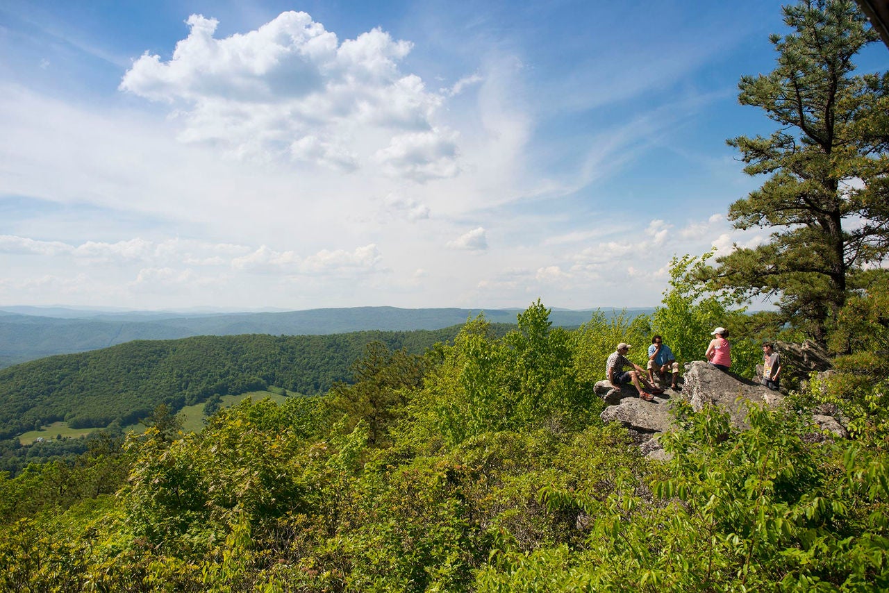 Family sitting on a rock looking over Hot Springs, Virginia